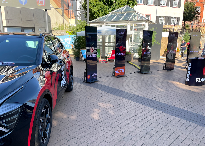 Mehrere digitale Rollups bei einer Outdoor-Veranstaltung vor einem Glaspavillon. Die Rollups zeigen Sponsoren und Vereinsbranding der Bensheim Flames.