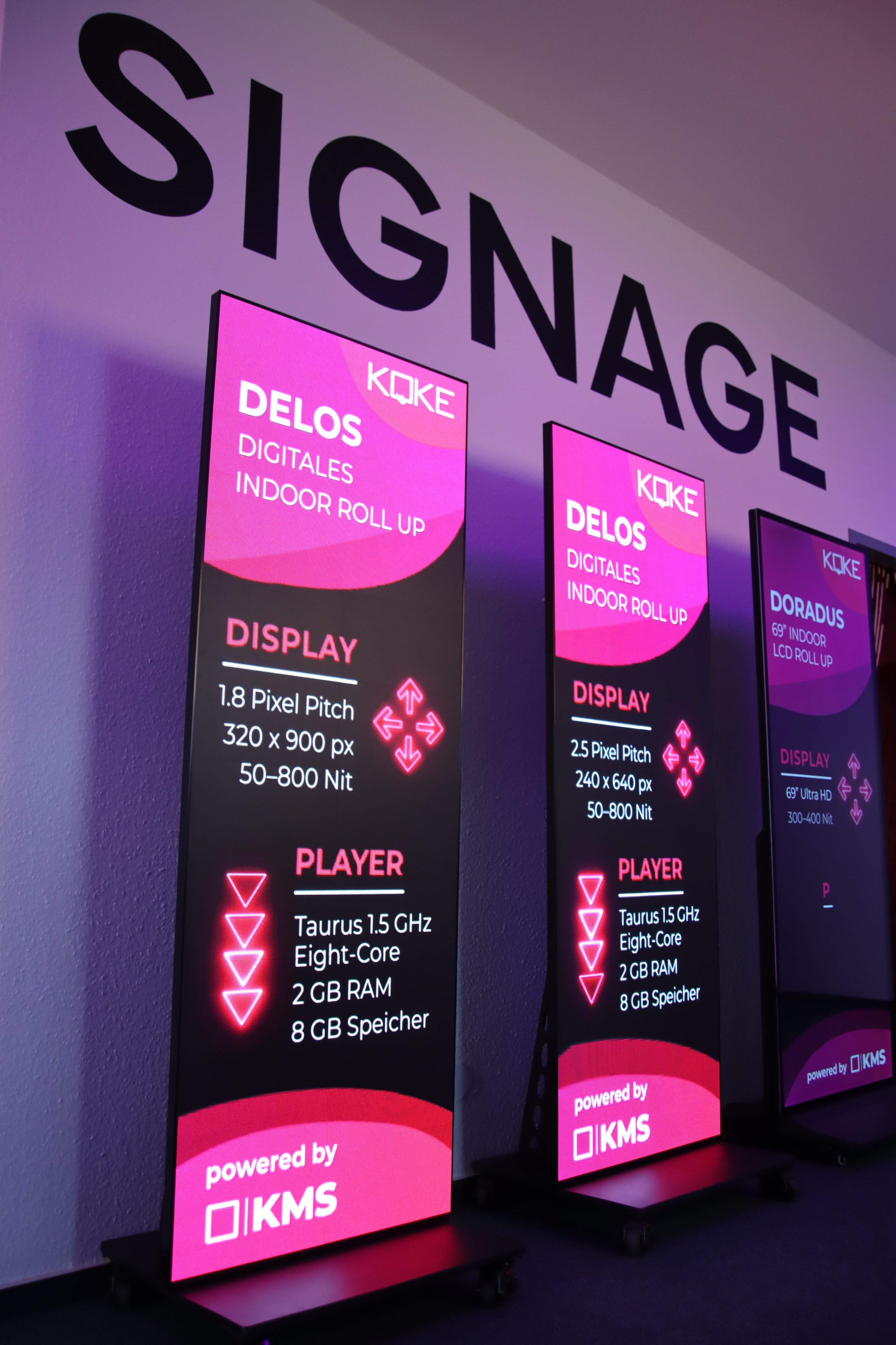 Drei digitale Roll-Ups vor einer Wand nebeneinander stehend. Zeigen Daten des Geräts als Inhalt.